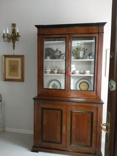 a wooden cabinet with dishes inside of it at La Falconiera in Vigevano