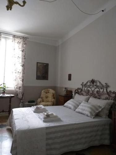 ein Schlafzimmer mit einem großen Bett und einem Stuhl in der Unterkunft La Falconiera in Vigevano