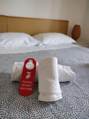 a stack of towels on a bed with a sign on it at Albergo Guido Reni in Turin