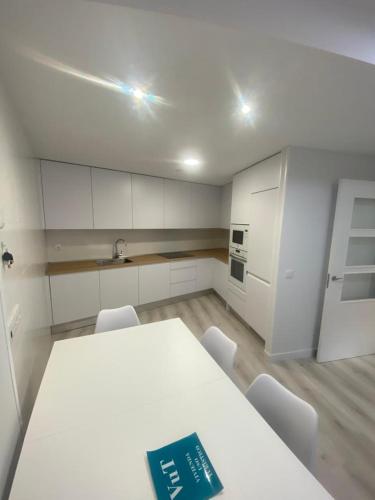 a white kitchen with a white table and chairs at Venerable Carabantes Soria Centro con Garaje in Soria