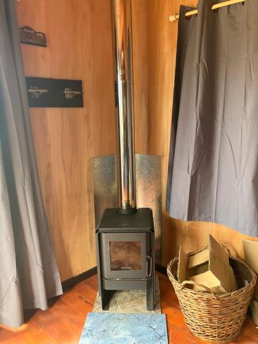 a wood stove in a room with a basket at El banzai in Punta Del Diablo