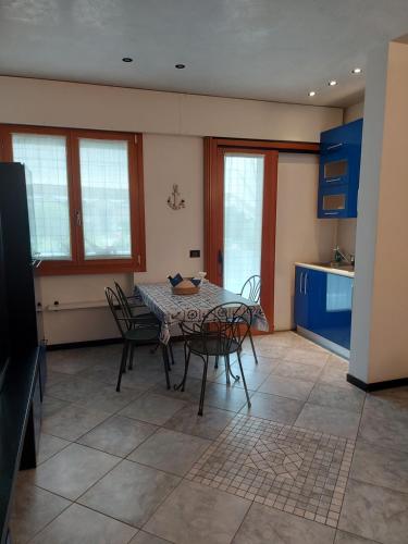 a kitchen with a table and chairs in a room at INDIGO APARTMENT Cavallino Treporti in Cavallino-Treporti