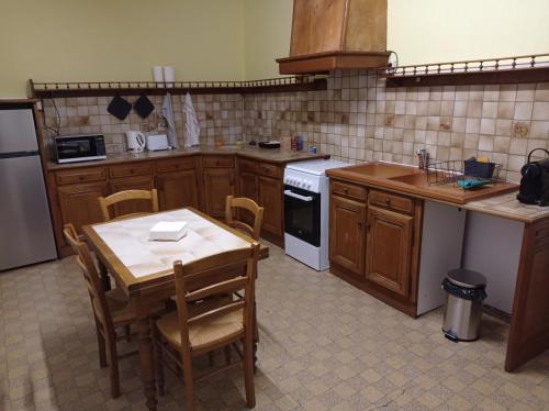 a kitchen with a table and chairs and a table and a stove at Appartement centre Saulieu in Saulieu