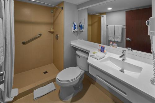 La salle de bains est pourvue de toilettes, d'un lavabo et d'un miroir. dans l'établissement City Express by Marriott Torreon, à Torreón
