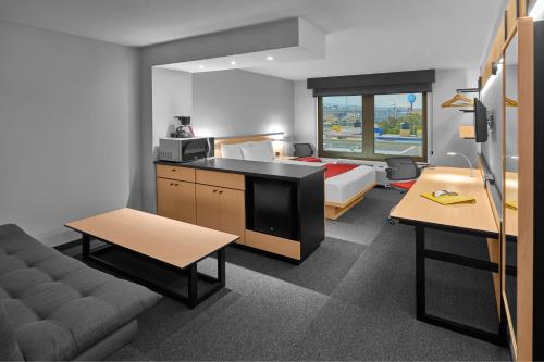 um quarto de hotel com uma cama e um sofá e um quarto em City Express by Marriott Monterrey Santa Catarina em Monterrey