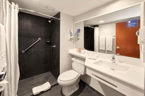 a bathroom with a toilet and a sink and a shower at City Express by Marriott Tampico Altamira in Tampico