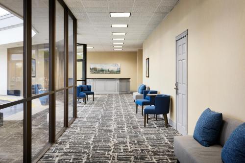 a waiting room with blue chairs and a table at Hilton Garden Inn Champaign/ Urbana in Champaign