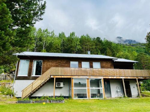 una casa de ladrillo con porche en un campo de hierba en Skjomen Lodge, en Elvegård