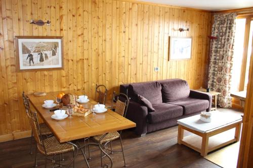 un salon avec une table et un canapé dans l'établissement Appartement Solaise Plein Sud By Valdiski, à Val dʼIsère