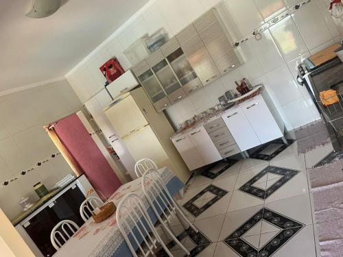 a kitchen with white cabinets and a tile floor at Chácara Sonho Realizado in São Pedro