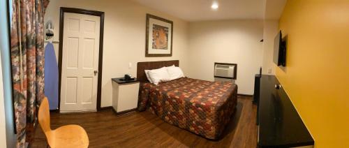 Budget Inn في سالزبوري: غرفه فندقيه بسرير وباب