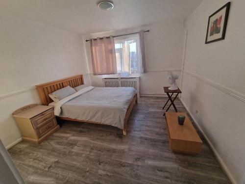 um pequeno quarto com uma cama e uma mesa em Luxury House, 4 bedrooms fully furnished em North Woolwich