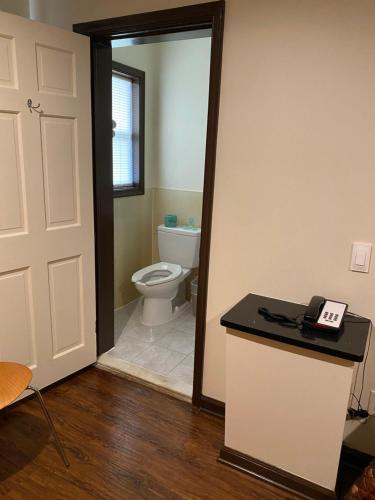 a bathroom with a toilet and a phone on a counter at Budget Inn in Salisbury