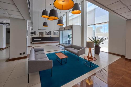 a living room with two couches and a blue rug at City Express by Marriott Queretaro Jurica in Quer&eacute;taro