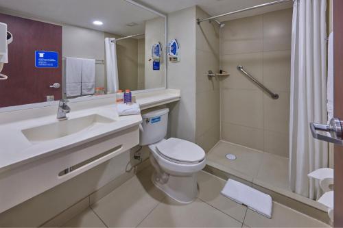 a bathroom with a toilet and a sink and a shower at City Express by Marriott Queretaro Jurica in Querétaro