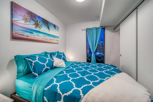 um quarto com uma cama azul e uma janela em Steps from downtown Calgary a Suite with a VIEW em Calgary