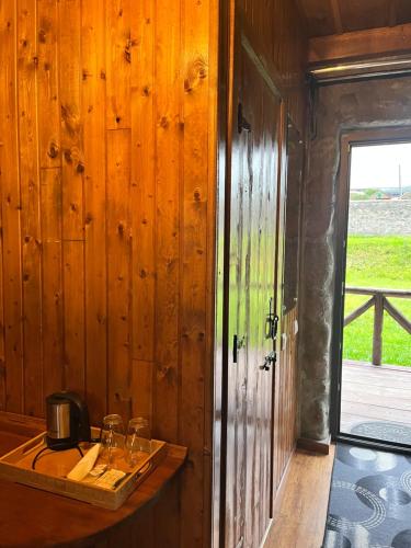 a wooden room with a counter with glasses on it at Inn Harmony in Stepantsminda