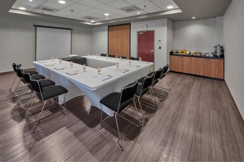 a conference room with a large white table and chairs at City Express by Marriott San Luis Potosi Zona Industrial in San Luis Potosí
