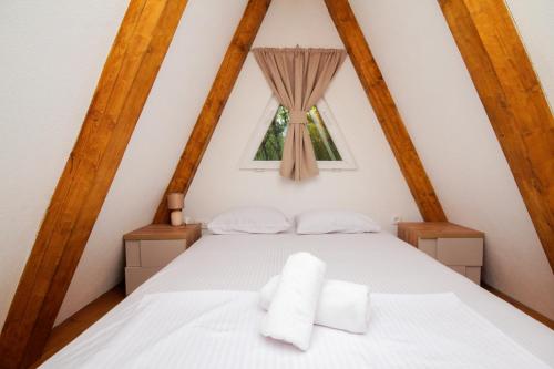 a bedroom with a white bed and a window at Vukova dolina in Cetinje