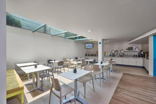een restaurant met tafels en stoelen en een keuken bij City Express Suites by Marriott Ciudad de México Anzures in Mexico-Stad