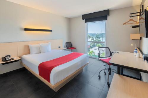 een hotelkamer met een bed, een bureau en een raam bij City Express by Marriott Tuxpan in Tuxpan de Rodríguez Cano