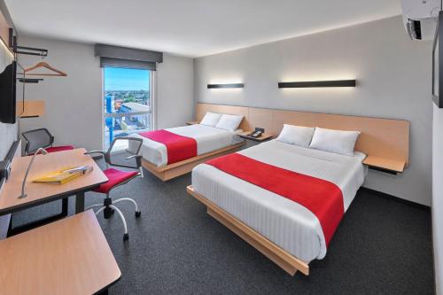 Habitación de hotel con 2 camas, escritorio y escritorio. en City Express by Marriott Matamoros, en Matamoros