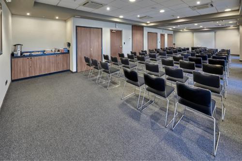 a room with rows of chairs and a podium at City Express by Marriott Matamoros in Matamoros
