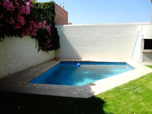 uma pequena piscina num quintal com flores em Casa en bonito barrio residencial - Ciudad em El Challao