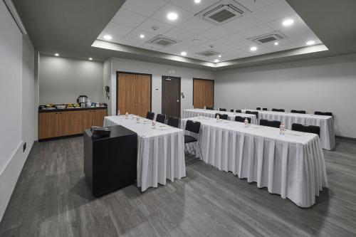 a room with tables and chairs with white table cloths at City Express by Marriott Ciudad de México Tlalnepantla in Mexico City