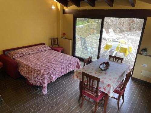 1 dormitorio con 1 cama, mesa y sillas en Agriturismo del Gao, en Isolabona