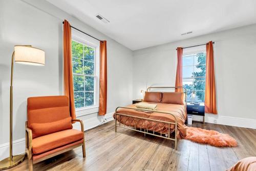 een slaapkamer met een bed, een stoel en ramen bij Big Bear-Downtown Truist Stadium in Winston-Salem