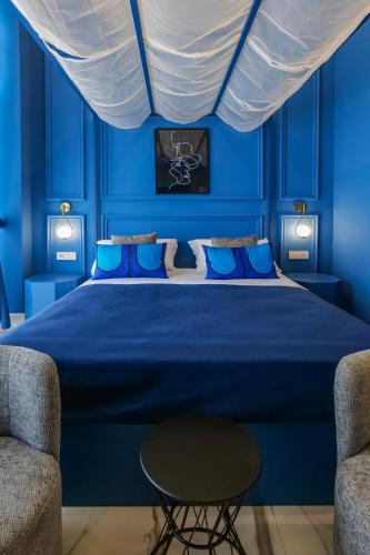 a blue bedroom with a large bed with blue walls at Maison San Carlo Luxury Suites in Naples