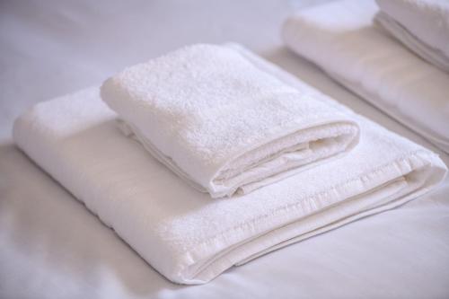 a pile of white towels sitting on top of a bed at Suite 3 - 1 Bed Apartment King Size Bed in Lincoln