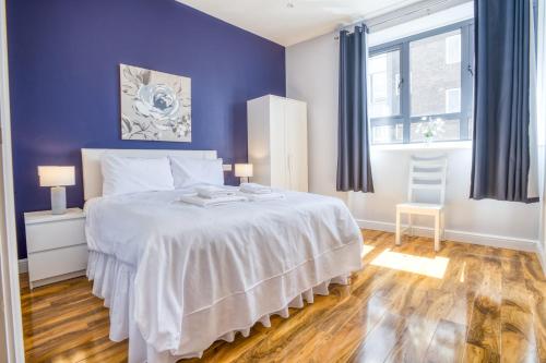 ein Schlafzimmer mit einem großen Bett mit lila Wänden in der Unterkunft Suite 1 - Class Apartment With King Sized Bed in Lincoln