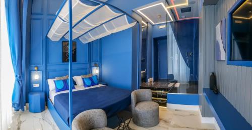 sypialnia z niebieskimi ścianami i łóżkiem z baldachimem w obiekcie Maison San Carlo Luxury Suites w mieście Napoli