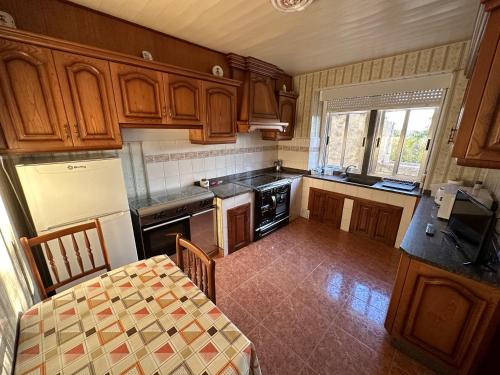 a kitchen with wooden cabinets and a table in it at Casa Balteiro in Cedeira