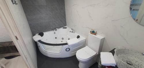 Baño blanco con aseo y lavamanos en Casa María, en Muxía