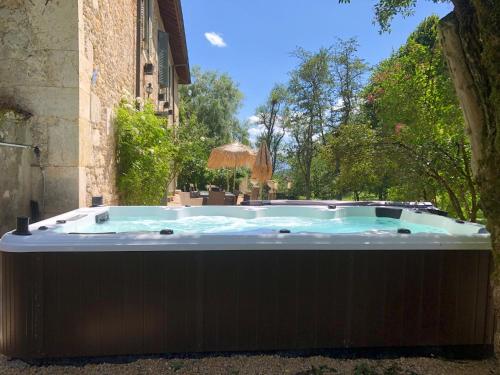 a hot tub in a yard next to a building at Domaine du Très-Haut - Château de Montanges in Montanges