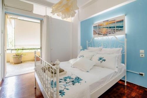 um quarto com uma cama branca e paredes azuis em Athens Paradise Apartament 50 sqm Near To Metro #2 em Atenas