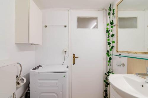 uma casa de banho branca com um lavatório e um espelho em Athens Paradise Apartament 50 sqm Near To Metro #2 em Atenas