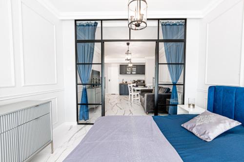 グダニスクにあるGlam & Loft Apartmentsのベッドルーム(青いベッド1台付)、リビングルーム
