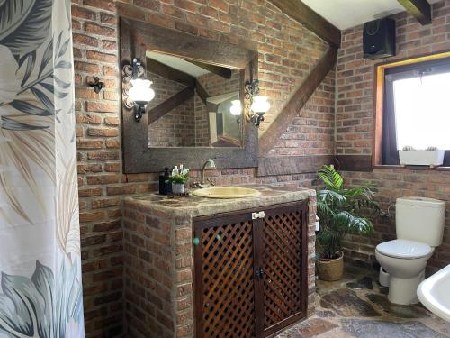 a brick bathroom with a sink and a mirror at Casa Rural La CaTaTa in Las Lagunas