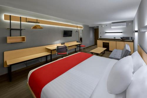 Habitación de hotel con cama grande y escritorio. en City Express by Marriott Ensenada en Ensenada