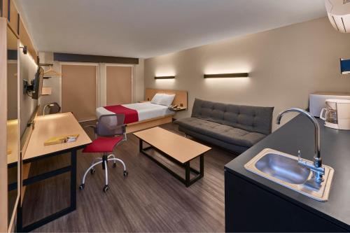 a small hotel room with a bed and a couch at City Express by Marriott Rosarito in Rosarito
