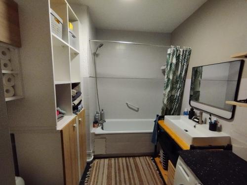 een badkamer met een bad en een wastafel bij Appartement cosy in Perpignan
