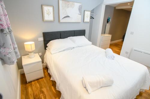 a bedroom with a white bed and a mirror at Cathedral View apartments in Lincoln