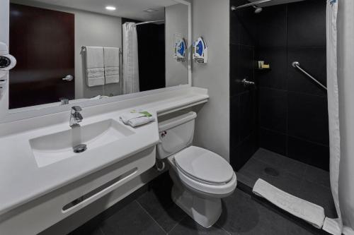 a bathroom with a toilet and a sink and a shower at City Express by Marriott Tijuana Rio in Tijuana