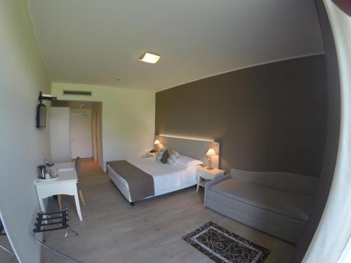 a bedroom with a bed and a couch and a table at Tullio Hotel in Gravedona