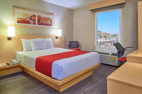 Habitación de hotel con cama grande y ventana en City Express by Marriott Zacatecas, en Zacatecas