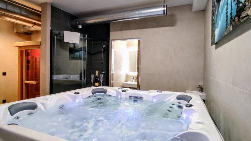 a large white bath tub in a bathroom at GRAND SPA Harrachov - Wellness luxusní apartmán s velkou vířivkou, saunou, kuchyní a venkovním posezením v centru Harrachova in Harrachov